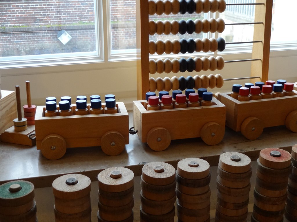 Wooden toy carts, stacking rings and an abacus by a sunny window